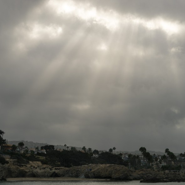 Picture of sunrays breaking through over the Wedge from Balboa Peninsula, Newport Beach, California, USA.